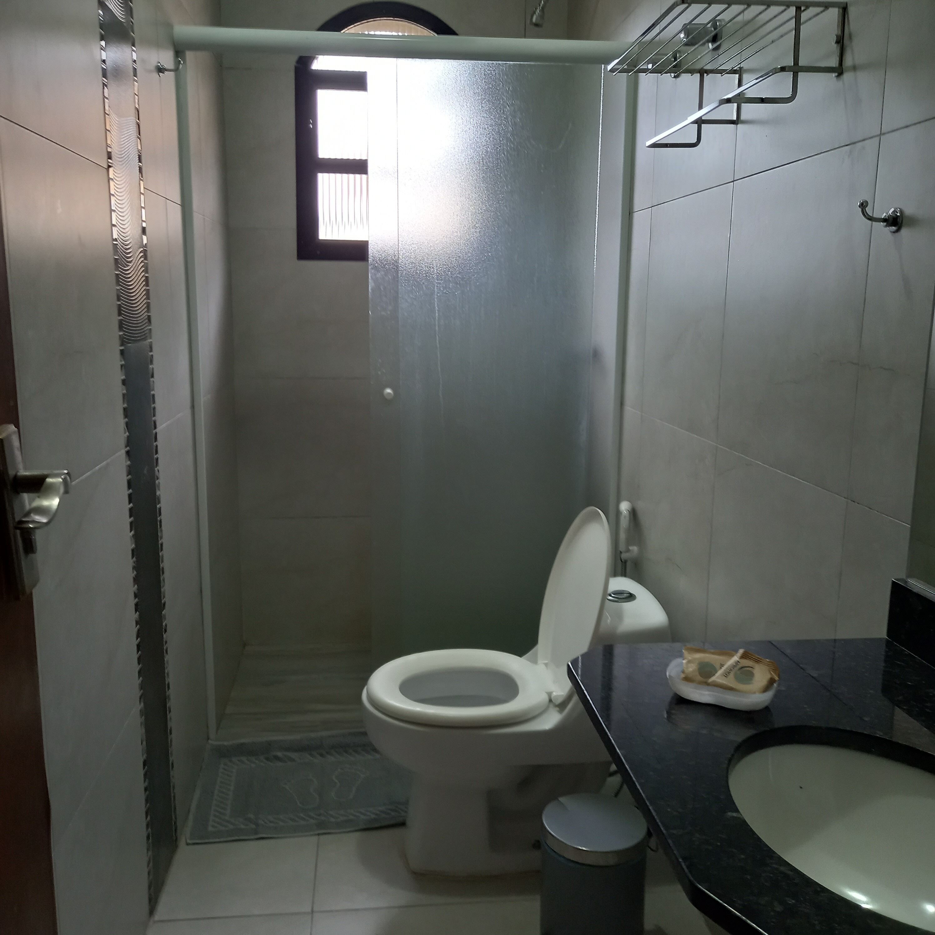 A small bathroom with a toilet, a sink, and a shower.