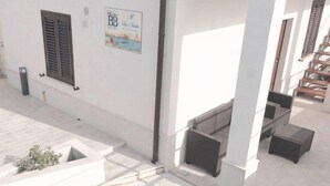 Un edificio con facciata bianca, un cartello con 'BB' e 'San Nevea', e una scalinata che conduce a un piano superiore.