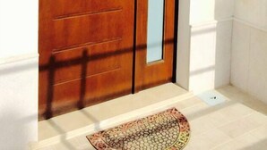 Una porta doppia in legno con un pannello di vetro verticale, una maniglia e un piccolo oblò rettangolare.