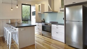 Una cucina moderna con isola centrale, elettrodomestici in acciaio inossidabile e vista sul verde.