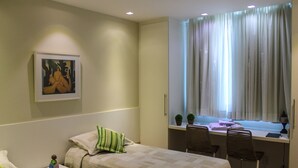 A bedroom with a bed, bedside table, and a desk with chairs. - Make yourself at home in the best spot in Copacabana (the beach block)! (Rio de Janeiro)