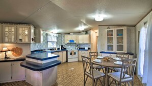Cozinha com ilha central, cadeiras de madeira e mesa de jantar.