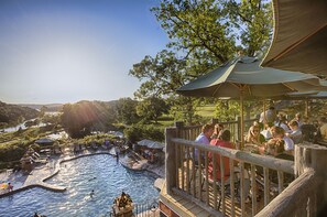 A pool area with a wooden deck, lounge chairs, and umbrellas. - Big Cedar Lodge (Ridgedale)