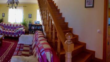 A living room with a sofa, a coffee table, and a staircase leading to a kitchen.