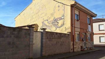 A building with a mural of a bicycle and handwritten text on its facade.