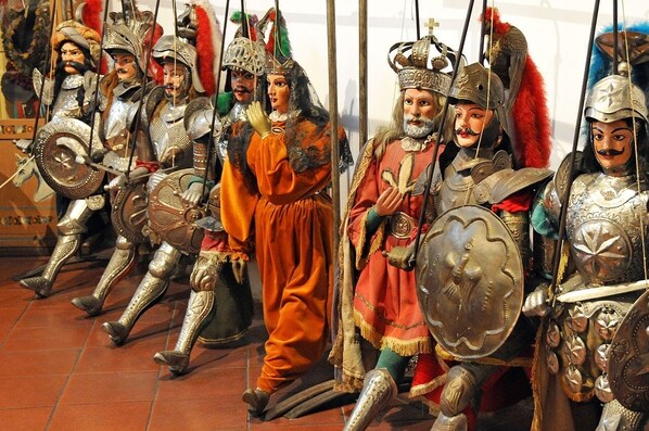 A row of historical figures in armor and costumes, likely part of a museum exhibit.