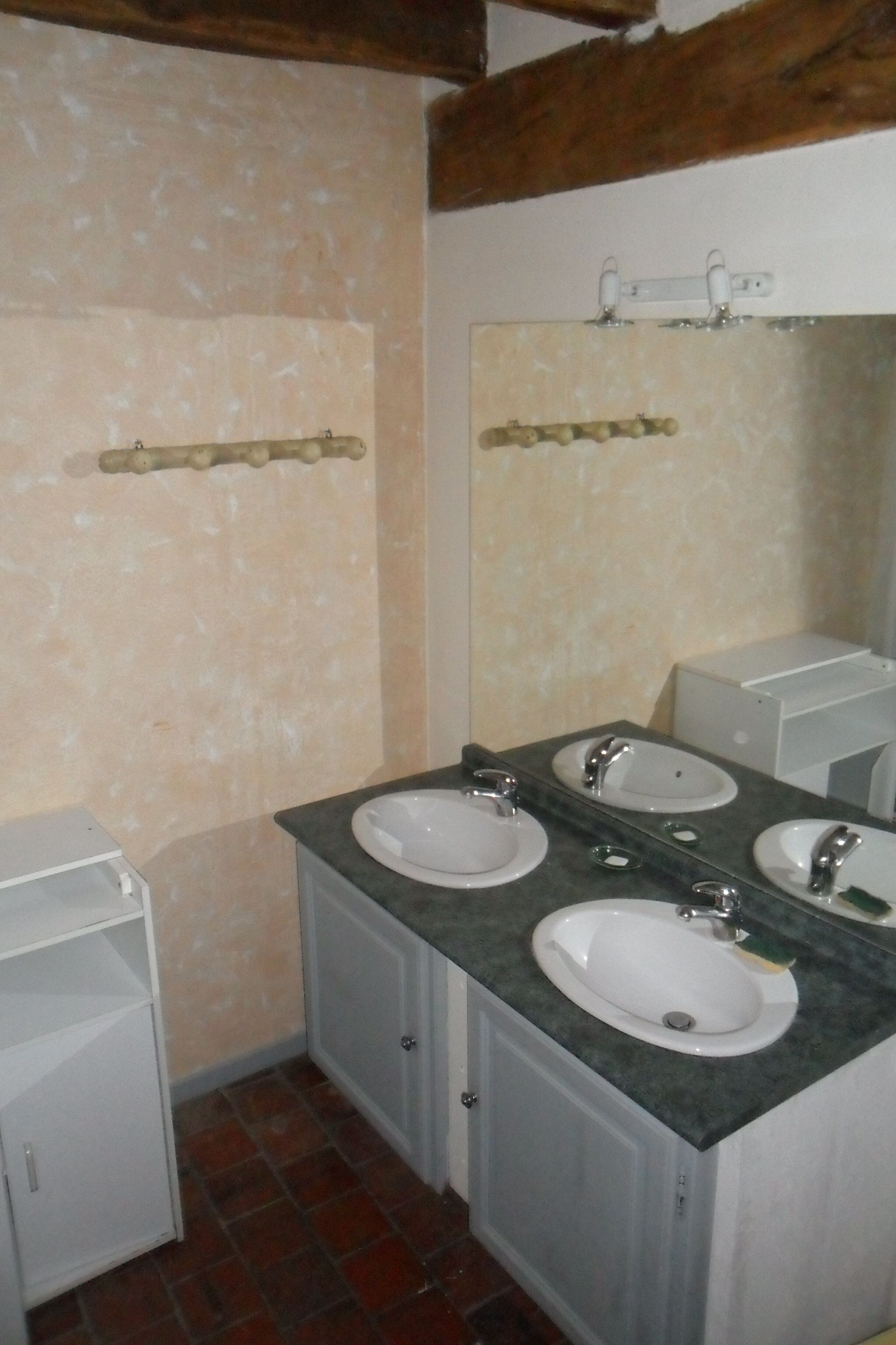 A bathroom with three sinks, a mirror, and a towel rack.