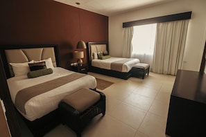 A hotel room with two beds, a desk, a lamp, and a large window with curtains. - Aldea Thai by Oceanfront (Playa del Carmen)