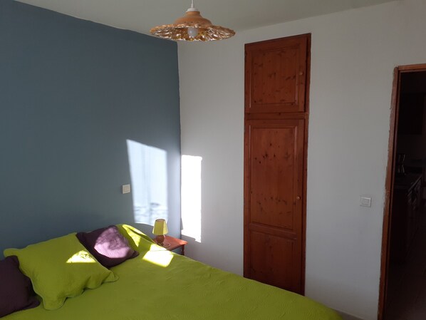 Une chambre à coucher avec un lit, une porte en bois et une fenêtre.