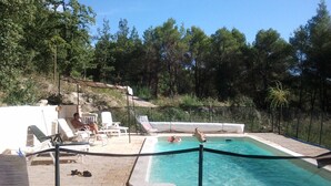 Un área de piscina con sillones de descanso y una piscina pequeña.