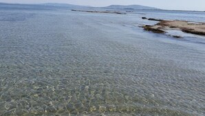 Klar udsigt til en strand med lavt vand og fjerne landskaber.