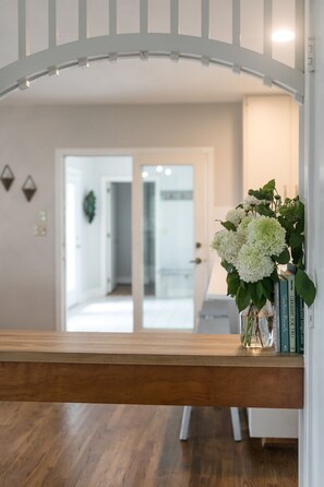 A wooden bench with a vase of white flowers and books on a table. - Oak Knob Equestrian Home (Campobello)