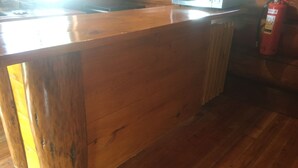 Eine Holztresenbar mit an der Wand montiertem Feuerlöscher.