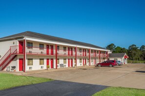 A motel with a two-story structure, multiple rooms, and a parking area.