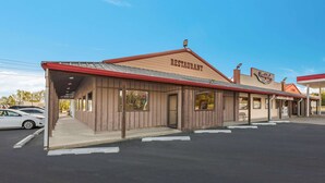 A restaurant with a red roof and wooden facade, located in a parking lot with a few cars. - Rodeway Inn Gurdon I-30 (Gurdon)
