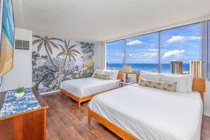 A hotel room with two beds, a large window with a city and ocean view, a tropical mural on the wall, and a small table with a plant. - 2bed/2bath Penthouse Ocean View...Recent Luxurious Renovation (Honolulu)