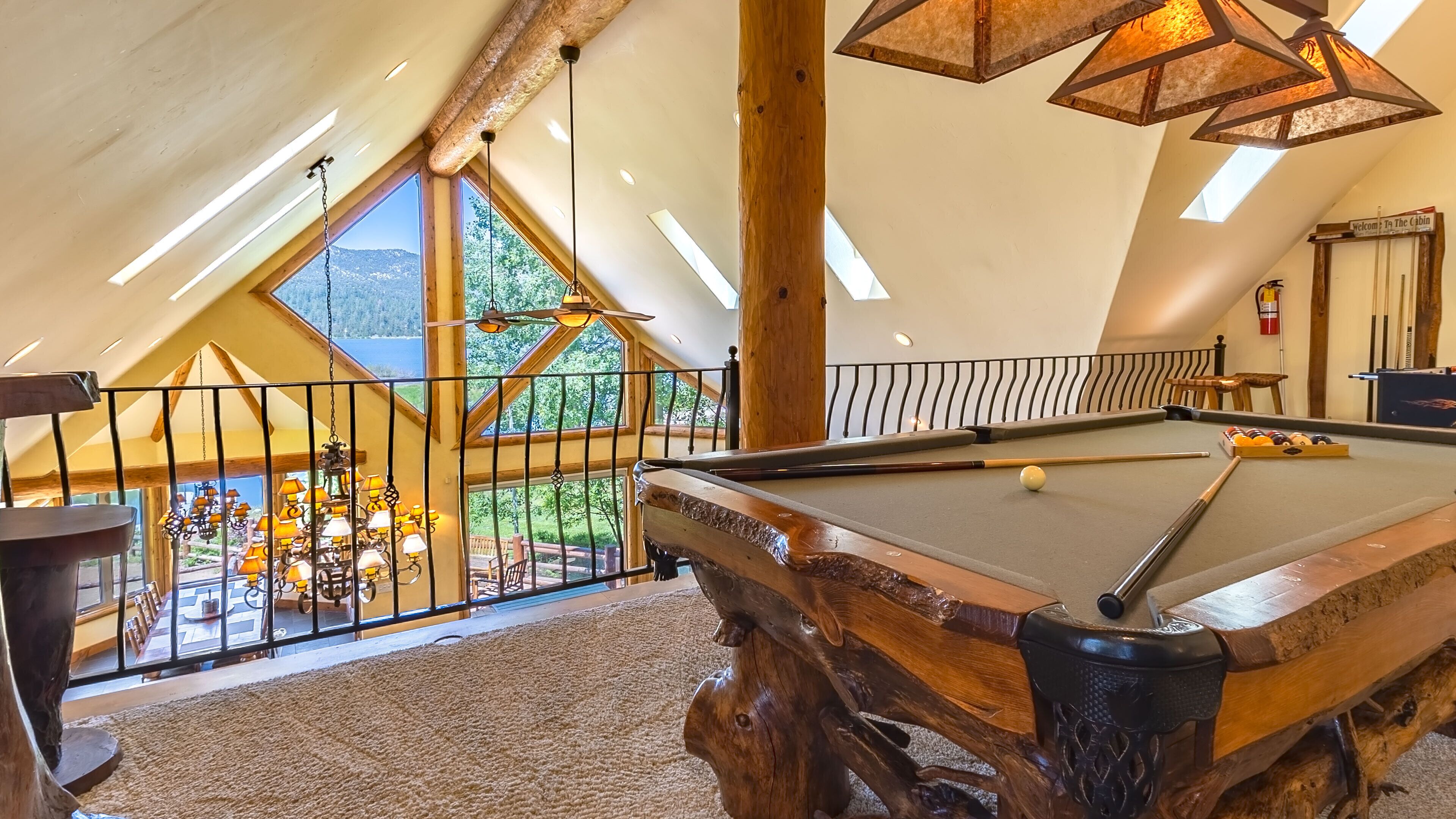 Une table de billard dans une pièce dotée d’un haut plafond et de grandes fenêtres.