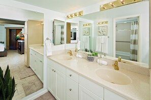 Une salle de bain moderne avec deux lavabos, de grands miroirs et un meuble-lavabo avec des placards.