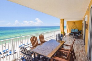 Ein Balkon mit Blick auf das Meer, einem Tisch, Stühlen und einer Ananas-Dekoration.