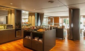 Une chambre d’hôtel moderne avec un plancher en bois, une grande fenêtre et un coin cuisine.