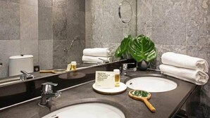 A modern bathroom with two sinks, a large mirror, and a potted plant. - Chic and Basic Velvet (Barcelona)