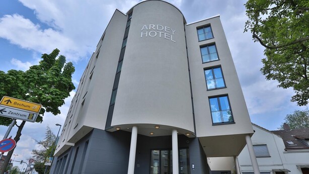 A modern hotel with a curved facade and a sign reading "Ardey Hotel." - Ardey Hotel (Witten)