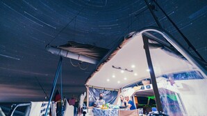 A tented area with a table set for dining, surrounded by various equipment and supplies. - iCan Sailing Experience (Turneffe Islands)