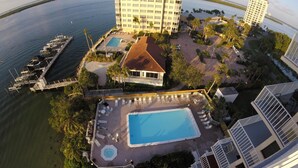 A high-rise hotel with a rooftop pool, a marina, and a small building with a red roof. - Lovers Key Beach Club by Lovers Key Vacations (Fort Myers Beach)