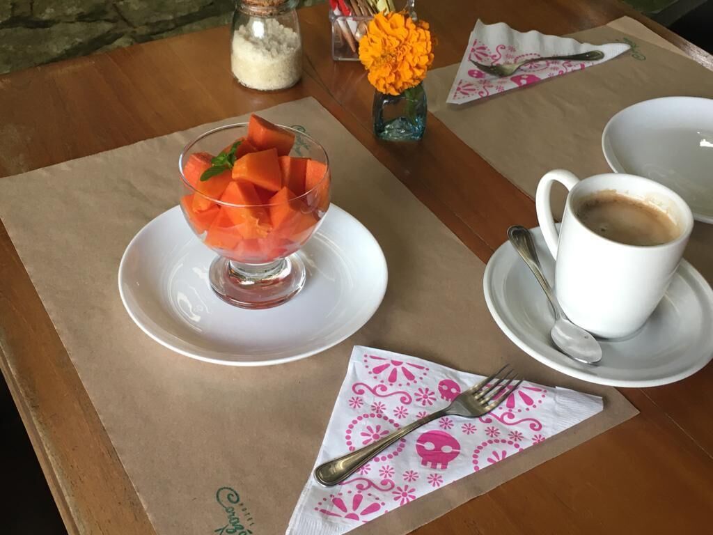 Ein Tisch mit einer Dessertschale, einer Kaffeetasse und einem Serviettenbild mit Totenkopf-Motiv.