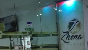 A hotel lobby with glass doors, a reception desk, and a logo on the wall. - Ayenda Zhena (San José de Cúcuta)