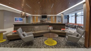 A modern lobby with a curved seating area, a central coffee table, and a wooden ceiling design. - SpringHill Suites by Marriott Fort Lauderdale Miramar (Miramar)