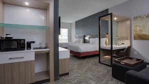 A modern hotel room with a kitchenette, a bed, a desk, and a seating area. - SpringHill Suites by Marriott Fort Lauderdale Miramar (Miramar)
