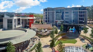 A modern building with a circular roof, a fountain, and outdoor seating areas.