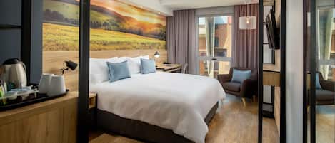 Een moderne hotelkamer met een groot bed, een bureau, een stoel en een televisie.