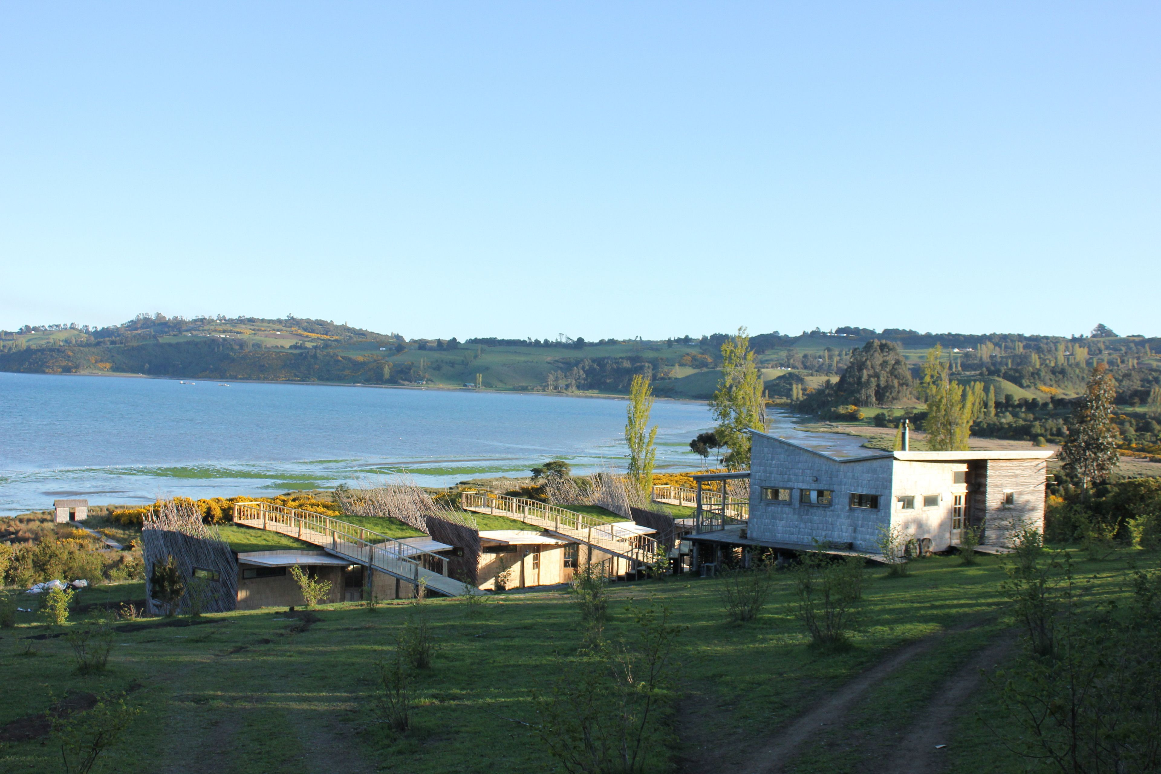 A lakeside property with a stone building, a wooden deck, and a view of the lake.