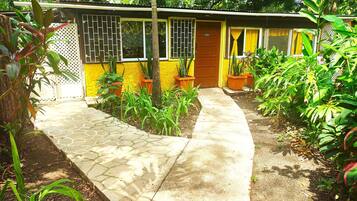 Un pequeño edificio de una sola planta con fachada amarilla y una puerta marrón que dice “OFFICE”.