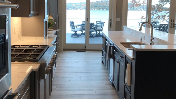 Una cucina moderna con un'isola grande, elettrodomestici in acciaio inossidabile e vista verso l'esterno.