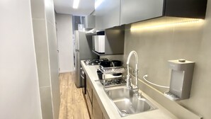 A modern kitchen with stainless steel appliances, a built-in dishwasher, and a large sink. - Spacious 2-bedroom apartment on Paulista Avenue. (São Paulo)