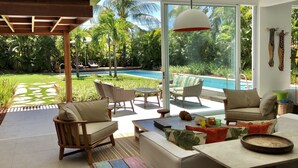 A modern outdoor living area with a pool, wicker furniture, and a view of the pool. - Beach house with 4 suites and a pool. Comfort and privacy just steps from the sea. (Camaçari)