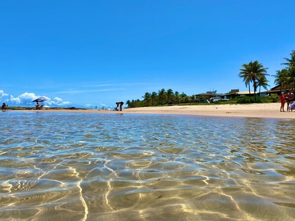 Na praia, espreguiçadeiras, toalhas de praia 
