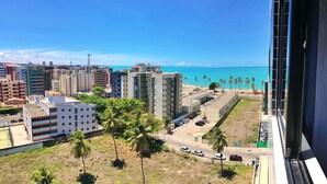 A coastal cityscape with high-rise buildings, a beach, and palm trees. - Vacation - edf. Port Ville III apt 1007 on the top floor with pool panoramic view (Jatiúca)