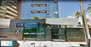 A modern building with a glass facade, a metal gate, and a sign for 'Motel Port Vila'.
