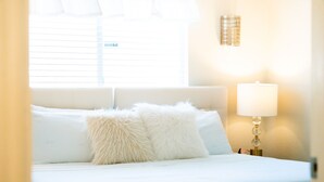 Un lit bien fait, avec des oreillers moelleux et une lampe de chevet.