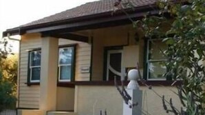 A house with a white picket fence and a sign that reads "Fitzgerald." - Fitzgerald Cape Paterson (Cape Paterson)
