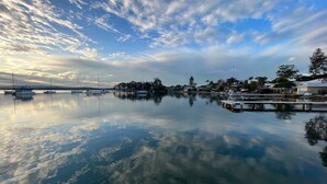 Un puerto deportivo con aguas tranquilas que reflejan el cielo y barcos.