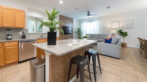 Una cocina moderna con encimeras de granito, armarios de madera y una isla central.