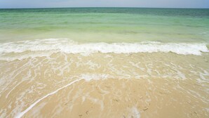 Uma praia com águas cristalinas e ondas suaves.