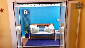 Een kamer met een houten bed, blauwe wanden, een klein raam en een ster decoratie.