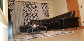 Relax in this stylish living room with a comfortable sofa, unique coffee table, and patterned rug.