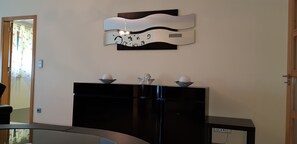 Experience the sleek, modern design of this stylish space, featuring a black cabinet and unique wall-mounted light fixture.